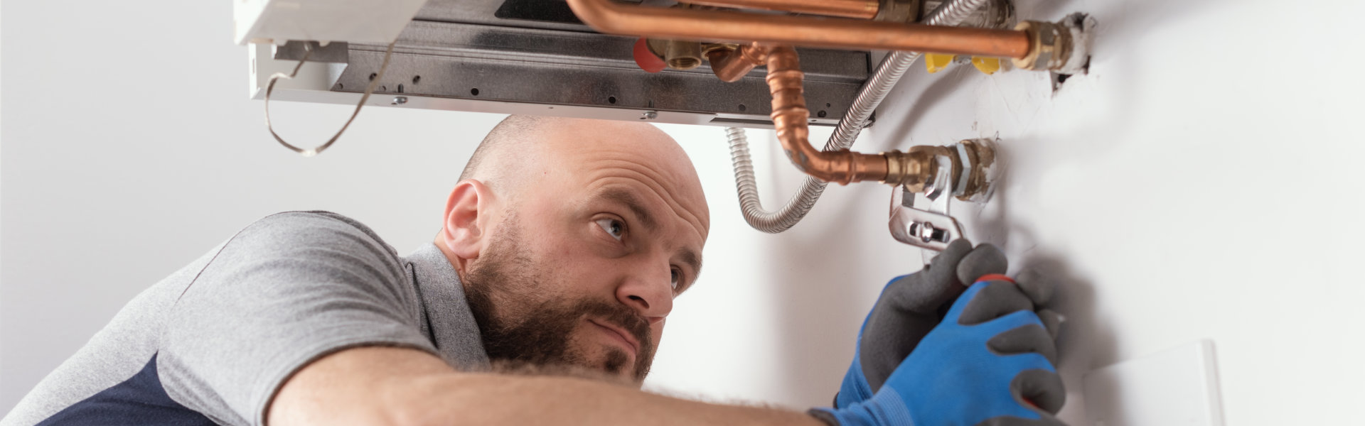 man repairing the pipe of the boiler