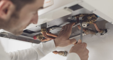 man fixing the pipes of the heater